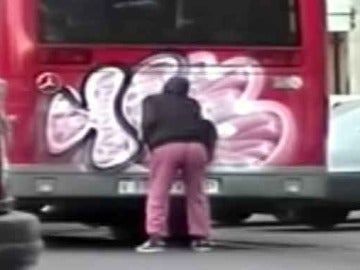 Graffitero pintando un autobus