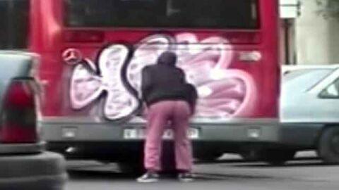 Graffitero pintando un autobus