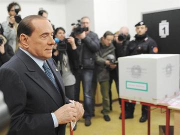 Berlusconi inserta su voto en urna urna electoral. 