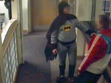 Un hombre disfrazado de Batman entrega un delincuente