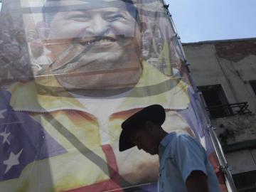 Un hombre pasa frente a una imagen del presidente de Venezuela Hugo Chávez