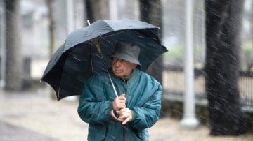 Un hombre se refugia de la lluvia en Vitoria