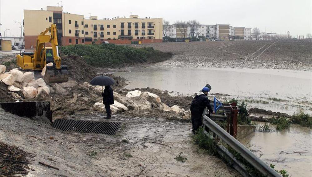 Una excavadora mueve tierra para levantar un dique que frene la entrada de agua del arroyo Argamasilla