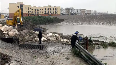 Una excavadora mueve tierra para levantar un dique que frene la entrada de agua del arroyo Argamasilla Una excavadora mueve tierra para levantar un dique que frene la entrada de agua del arroyo Argamasilla