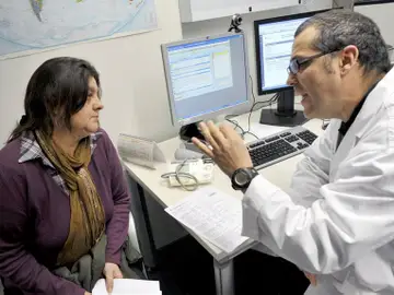 Un doctor en una consulta médica con una paciente Un doctor en una consulta médica con una paciente