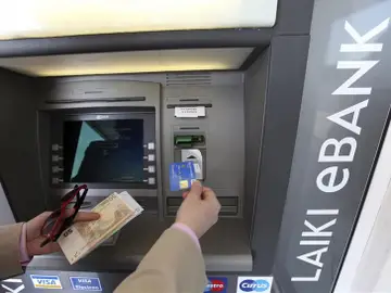 Un hombre saca dinero de un cajero automático en Nicosia Un hombre saca dinero de un cajero automático en Nicosia