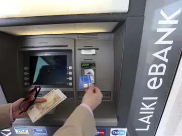 Un hombre saca dinero de un cajero automático en Nicosia Un hombre saca dinero de un cajero automático en Nicosia
