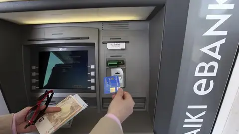 Un hombre saca dinero de un cajero automático en Nicosia Un hombre saca dinero de un cajero automático en Nicosia