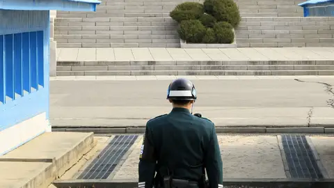 Un soldado surcoreano en guardia frente a uno norcoreano Un soldado surcoreano en guardia frente a uno norcoreano