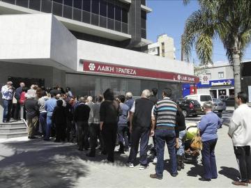 Pequeñas colas en frente de un banco chipriota.
