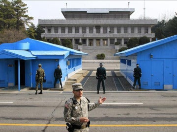 Soldados surcoreanos (de espaldas a la cámara) observan a un soldado norcoreano.