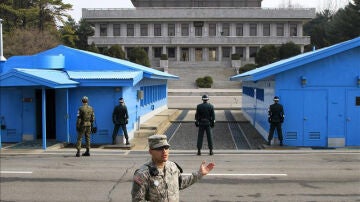 Soldados surcoreanos (de espaldas a la cámara) observan a un soldado norcoreano.