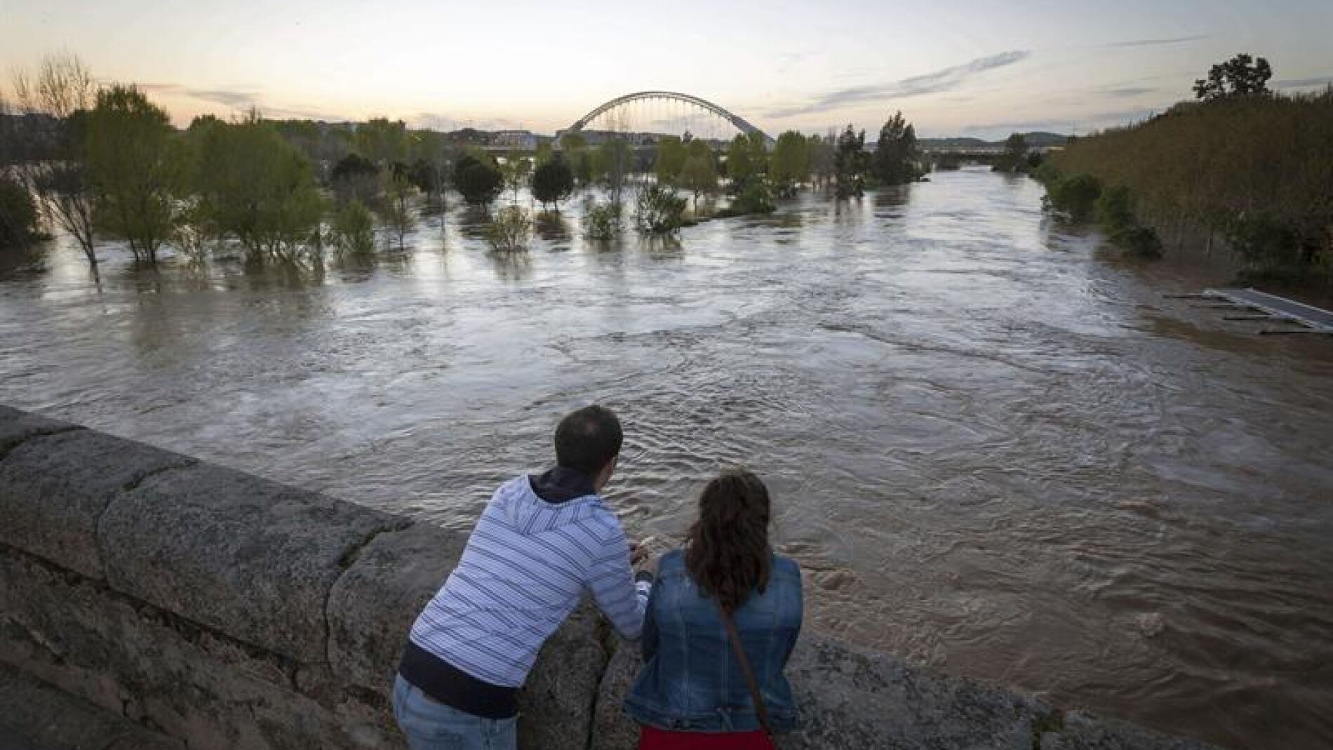 Varias personas observan la crecida del r&iacute;o Guadiana, a su paso por M&eacute;rida