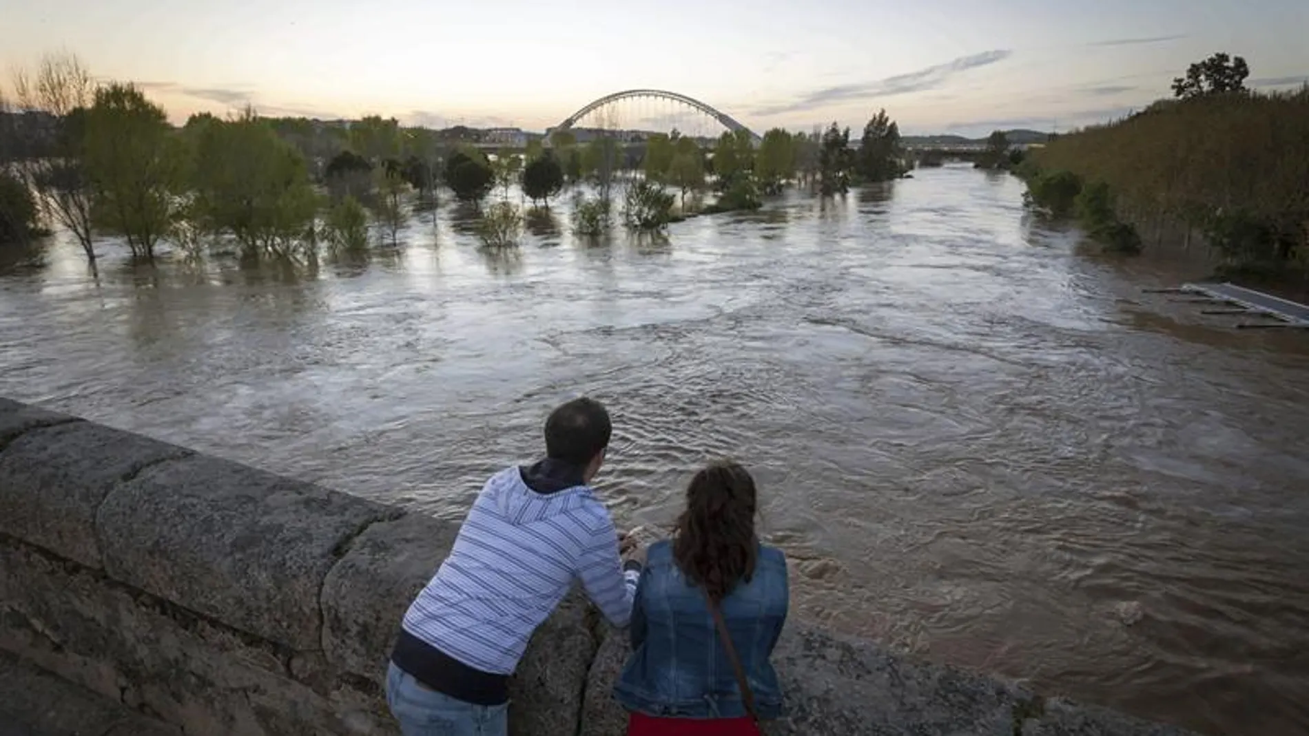 Varias personas observan la crecida del río Guadiana, a su paso por Mérida Varias personas observan la crecida del río Guadiana, a su paso por Mérida