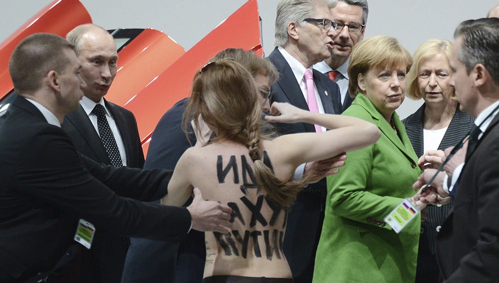 El presidente ruso, Vladimír Putin, y la canciller alemana, Angela Merke, se ven sorprendidos por una activista de Femen