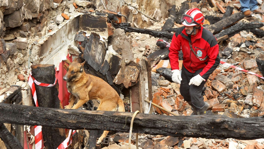 Un miembro de Unidad de Rescate busca posibles víctimas entre los escombros de una casa de Bermeo