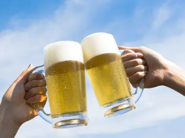 Dos personas brindan con cerveza Dos personas brindan con cerveza