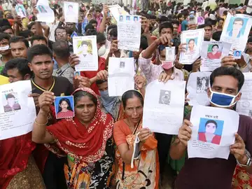 Familiares de las víctimas muestran imágenes de las personas fallecidas por el derrumbe en Bangladesh Familiares de las víctimas muestran imágenes de las personas fallecidas por el derrumbe en Bangladesh