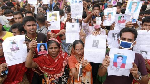 Familiares de las v&iacute;ctimas muestran im&aacute;genes de las personas fallecidas por el derrumbe en Bangladesh