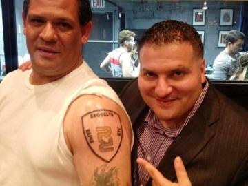 Anthony Lolli, dueño de Rapid Realty, posa con uno de sus empleados tatuados