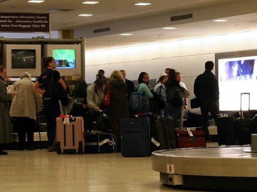 Pasajeros esperando con sus maletas