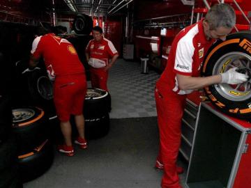 Mecánicos del equipo Ferrari trabajan con los neumáticos 