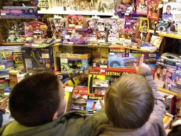 Unos niños miran un escaparate lleno de juguetes