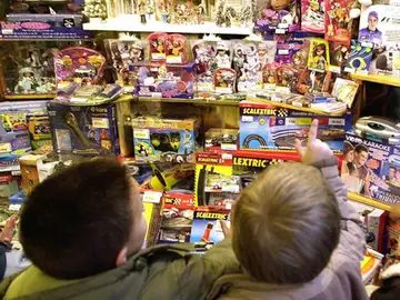 Unos niños miran un escaparate lleno de juguetes Unos niños miran un escaparate lleno de juguetes