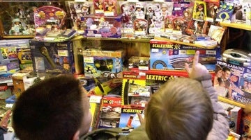 Unos niños miran un escaparate lleno de juguetes