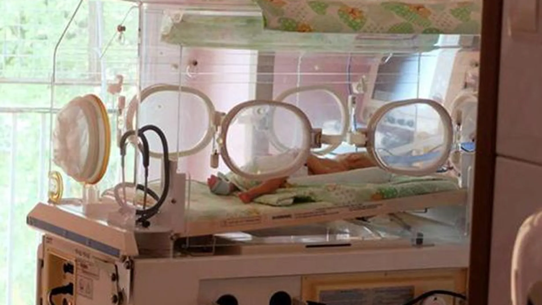 Un bebé en una incubadora Un bebé en una incubadora