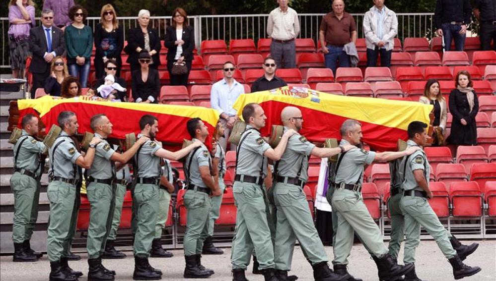 Varios legionarios portan los féretros de los tres suboficiales fallecidos