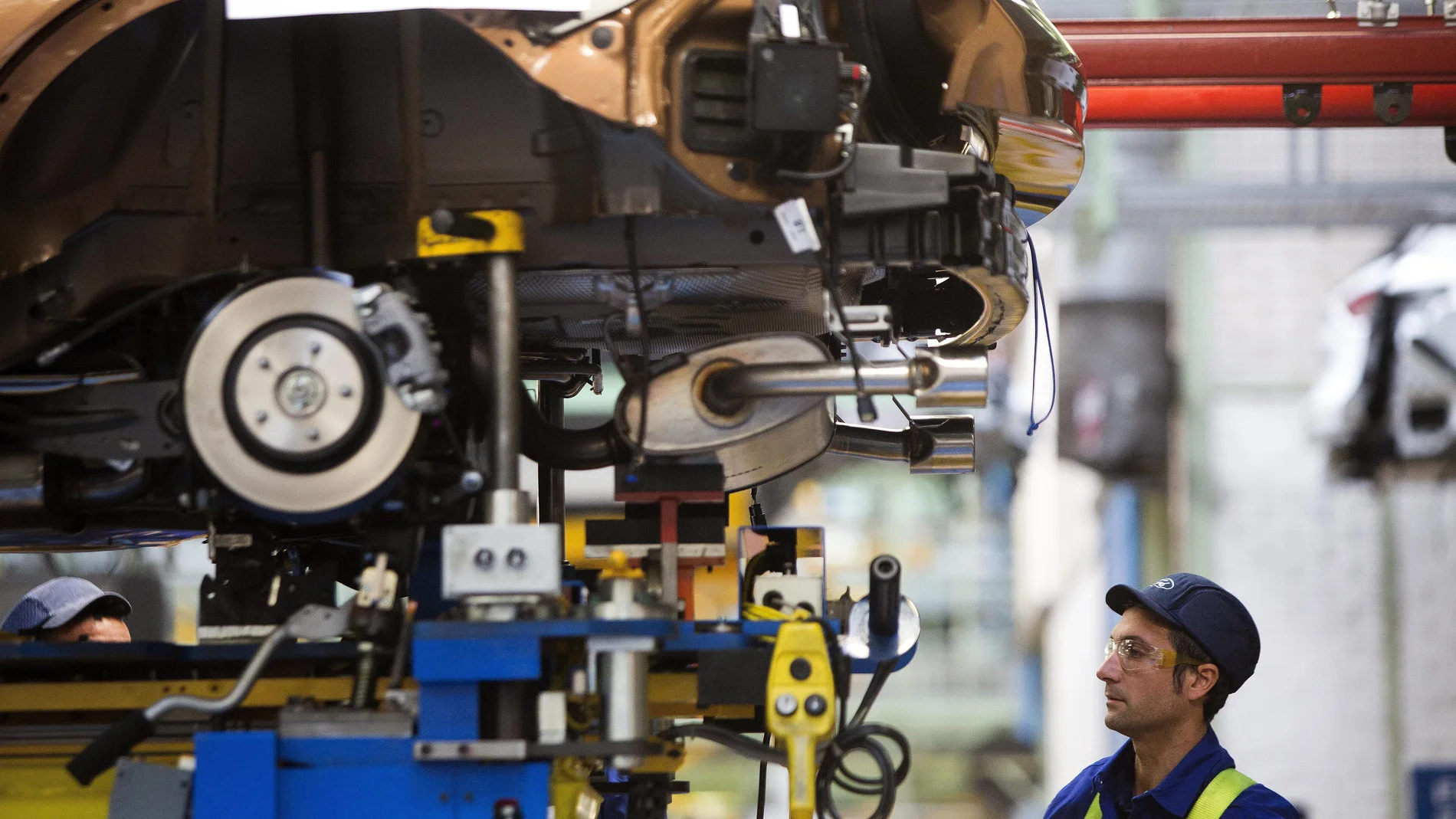 Un trabajador en la cadena de montaje de Ford Un trabajador en la cadena de montaje de Ford