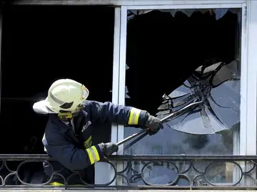 Un efectivo del cuerpo de Bomberos rompe una ventana durante un incendio en Getxo. Un efectivo del cuerpo de Bomberos rompe una ventana durante un incendio en Getxo.