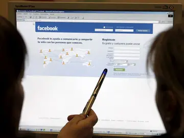 Dos jóvenes acceden a Facebook Dos jóvenes acceden a Facebook