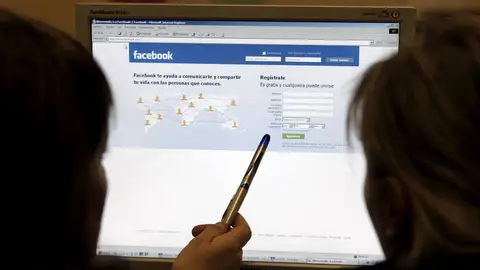Dos jóvenes acceden a Facebook Dos jóvenes acceden a Facebook