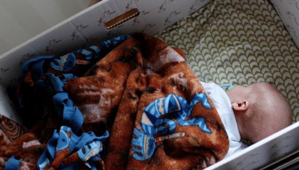 El bebé duerme en una caja