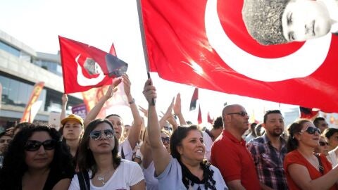 Manifestantes corean sus eslogan contra el Gobierno ondeando la bandera nacional