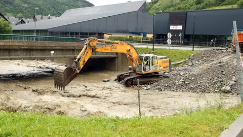 Una excavadora trabaja en el cauce del río Garona Una excavadora trabaja en el cauce del río Garona