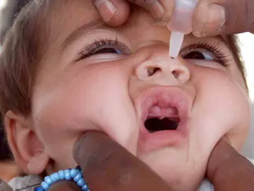 Un niño recibe la vacuna de la polio Un niño recibe la vacuna de la polio