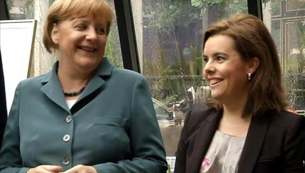 La canciller alemana Angela Merkel hablando con la vicepresidenta del Gobierno español, Soraya Sáenz de Santamaría