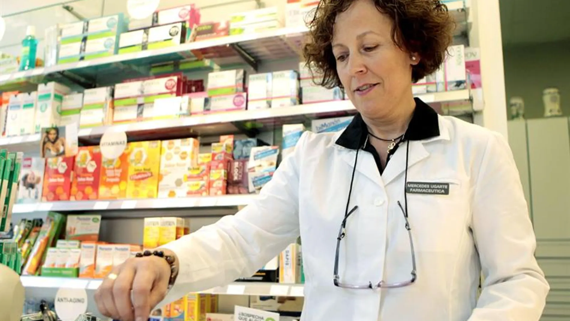 Una mujer atendiendo en una farmacia Una mujer atendiendo en una farmacia