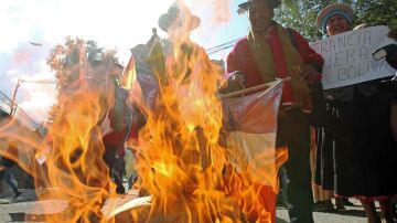 Un grupo de persona quema banderas francesas y de la Unión Europea en Bolivia