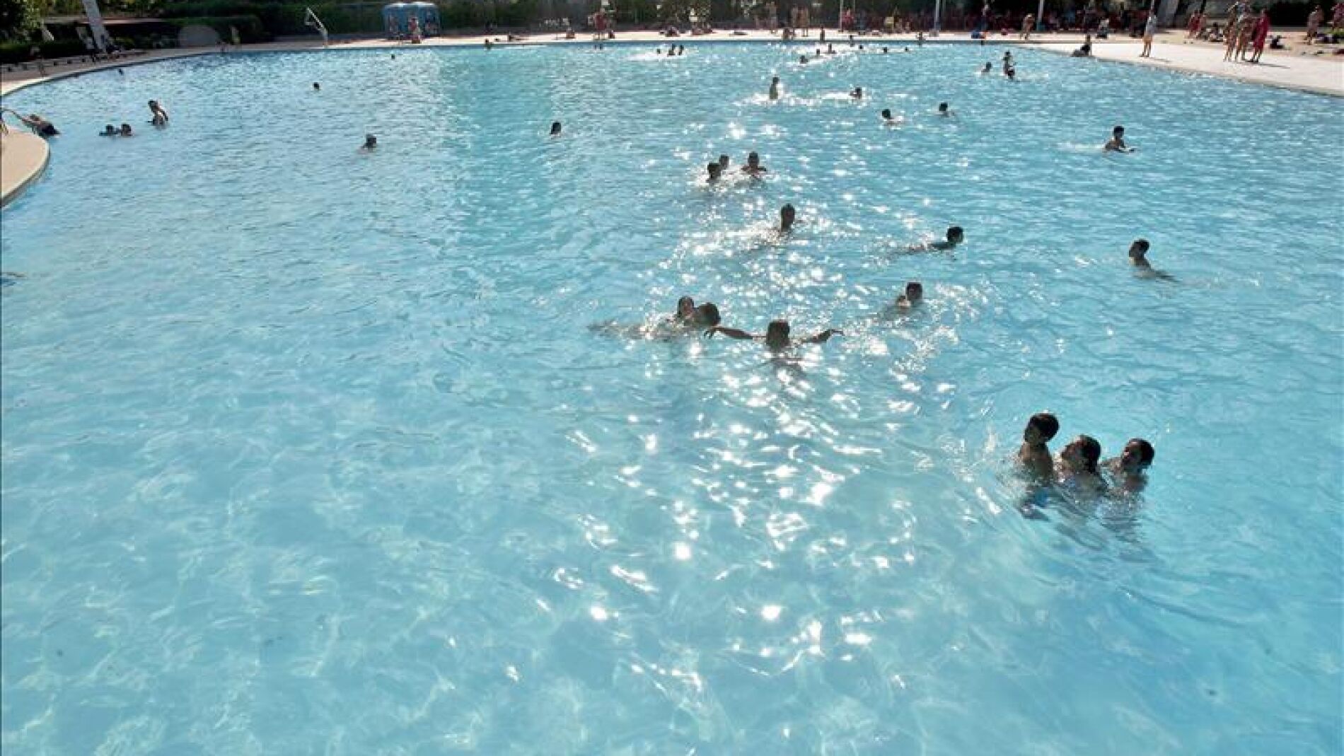 Varias personas se dan un ba&ntilde;o en una piscina