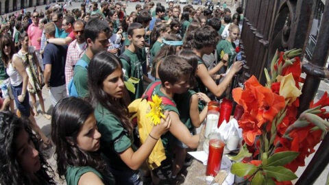 Los peregrinos depositan flores, velas y notas en la fachada de catedral de Santiago