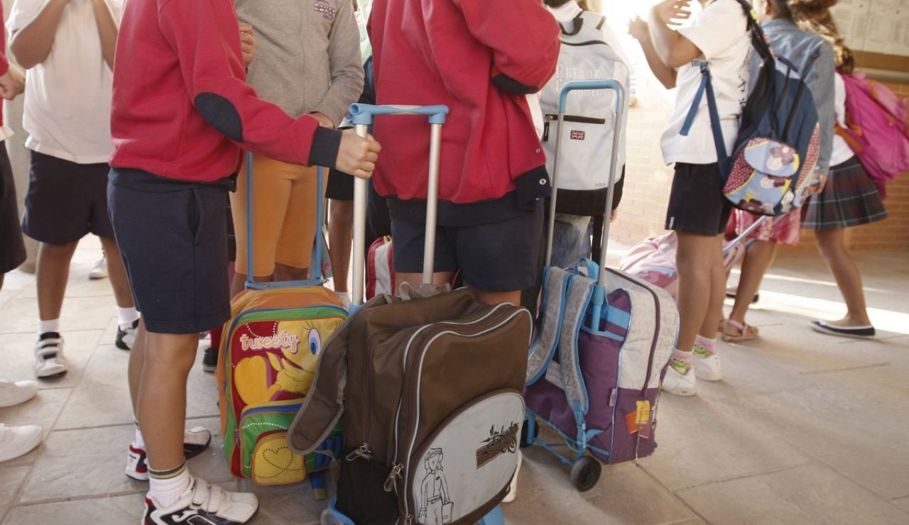 Varios niños llegan con sus mochilas al colegio. Varios niños llegan con sus mochilas al colegio.