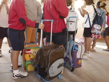 Varios niños llegan con sus mochilas al colegio. Varios niños llegan con sus mochilas al colegio.