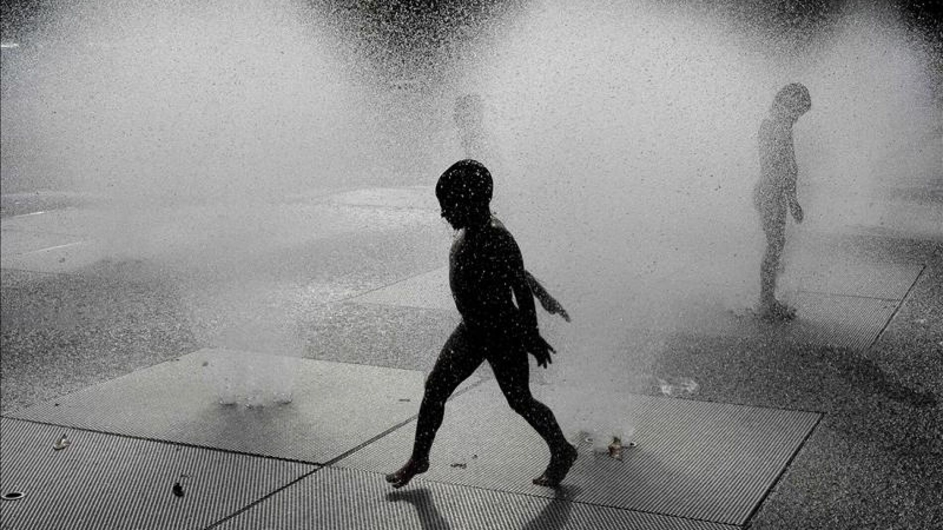 Un ni&ntilde;o se refresca en una fuente