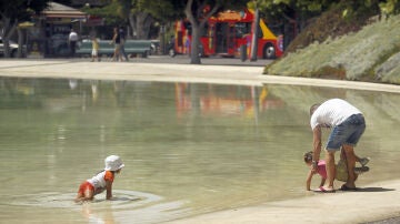 Dos niños se refrescan en un lago