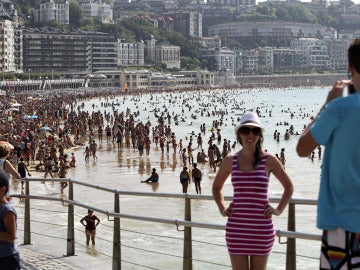 Dos turistas se fotografían junto a la playa de La Concha de San Sebastián.