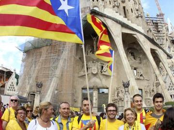 Varias personas congregadas frente a la Sagrada Familia participan en la cadena humana 